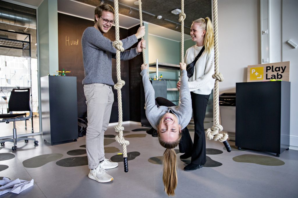 En smilende studerende klatrer i torv