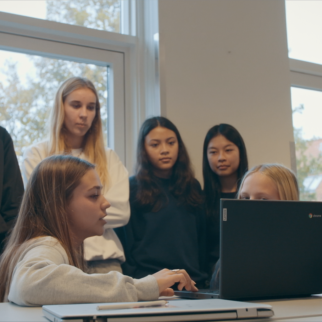 En gruppe børn, der samarbejder om en opgave på computeren