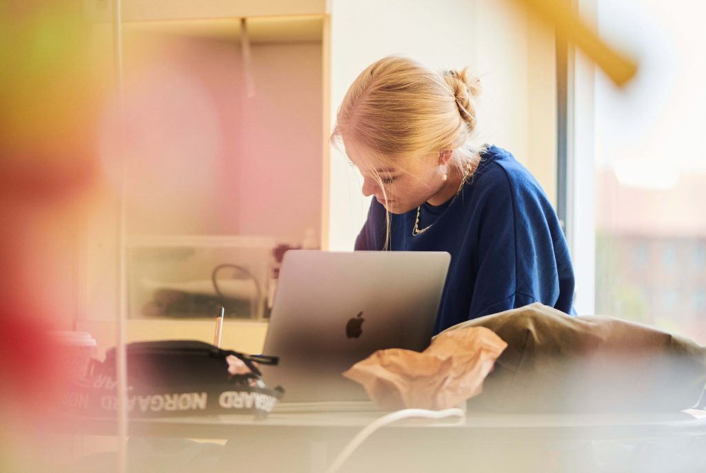 En elev, der sidder alene ved sin computer.