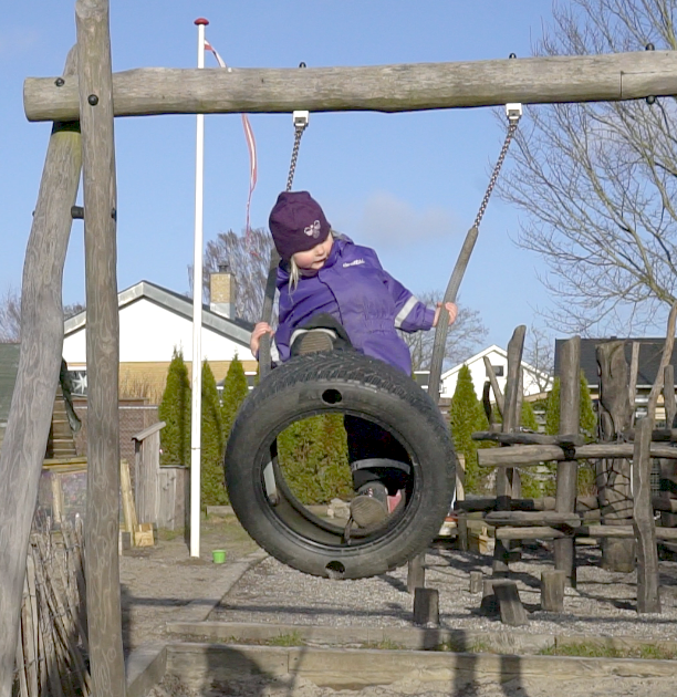Et barn, der gynger på en legeplads