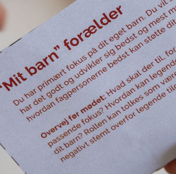 Et rollespilskort og en række materialer i baggrunden, som viser, hvordan værktøjet kan se ud i praksis