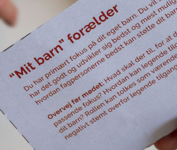 Et rollespilskort og en række materialer i baggrunden, som viser, hvordan værktøjet kan se ud i praksis